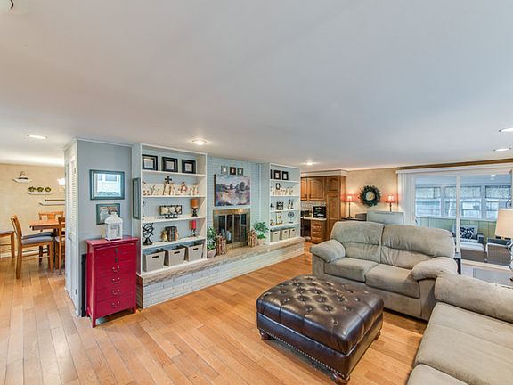 Living room with bookcase and fireplace and of course wood floors.