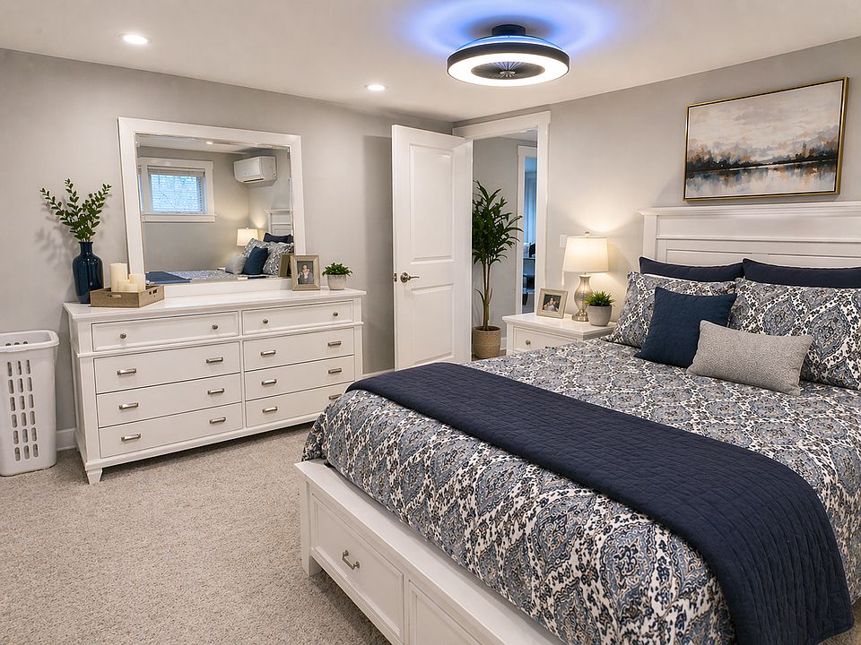 Serene bedroom retreat with modern finishes, recessed lighting, and energy-efficient split-unit climate control for year-round comfort.