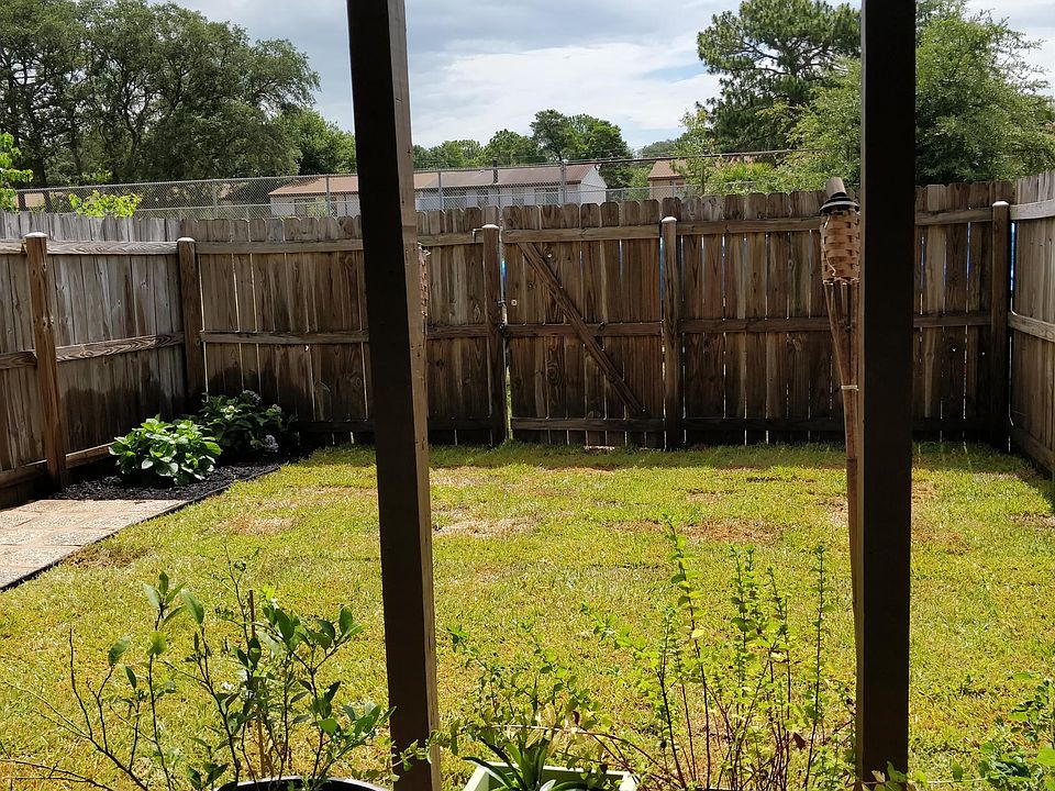 Backyard (Grass is patchy now, but exists and with care will be great again in the spring. Plants to the left rear are removed and that area is for you to plant your own items such as tomatoes or peppers. We have a sprinkler system on a timer installed t