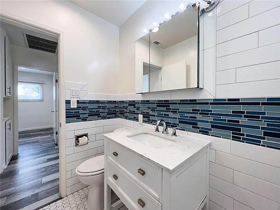 Updated bathroom with white shaker vanity, subway tile and coastal inspired tile inlay
