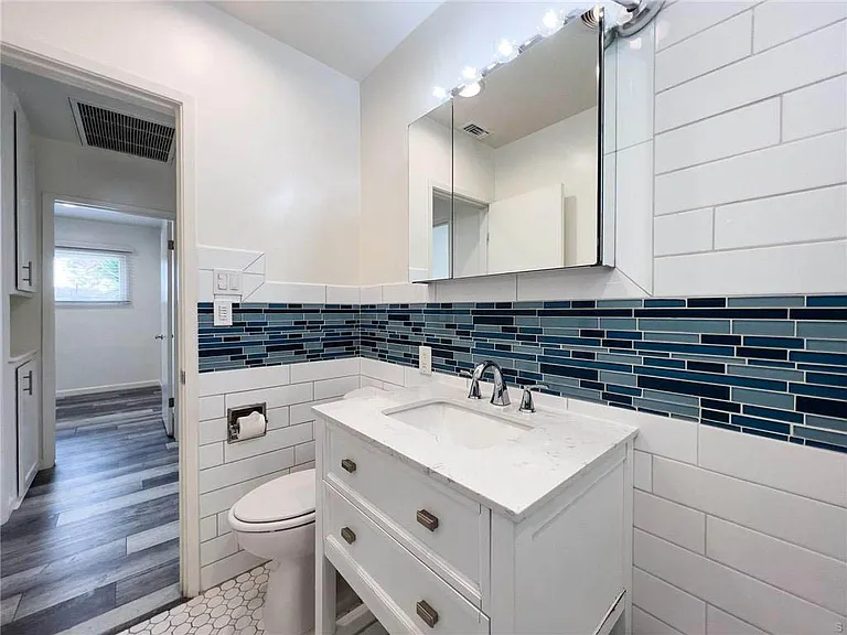 Updated bathroom with white shaker vanity, subway tile and coastal inspired tile inlay