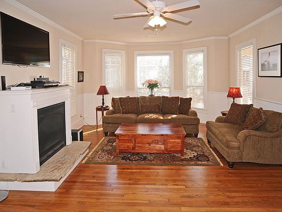 Living room has a sunny bay window, goregous pine floors & gas fireplace.