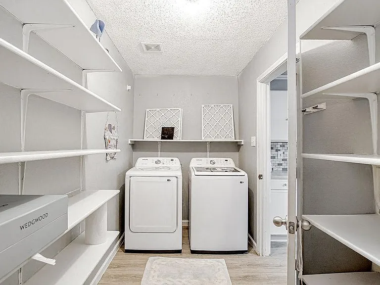Dedicated laundry room with washer and dryer, plus extensive built-in shelving for supplies and extra storage.