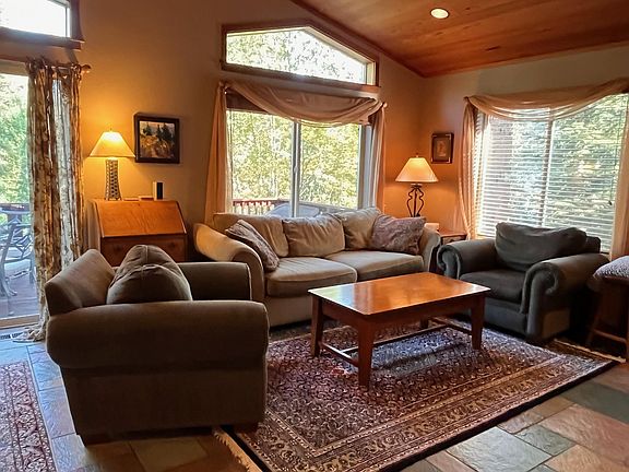 Family room (upstairs) with slate floor, redwood ceilings, oriental rugs, sliding door to deck, antiques, lots of light