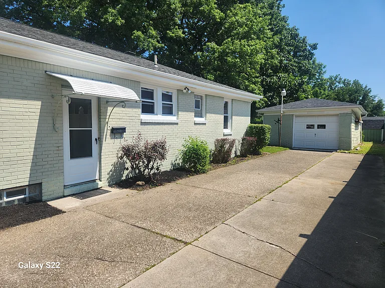 Side entrance to house, garage, and driveway.