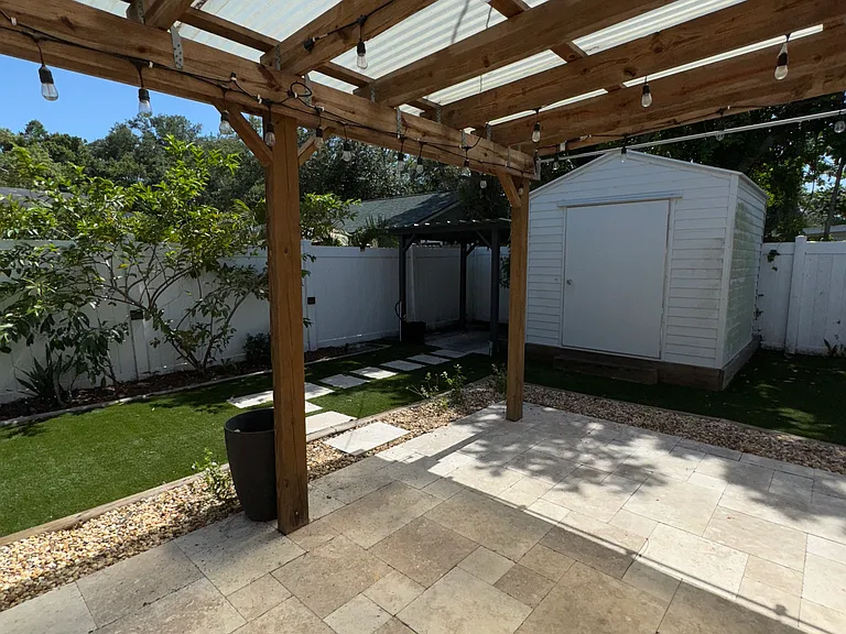 Pergola-covered patio in backyard.