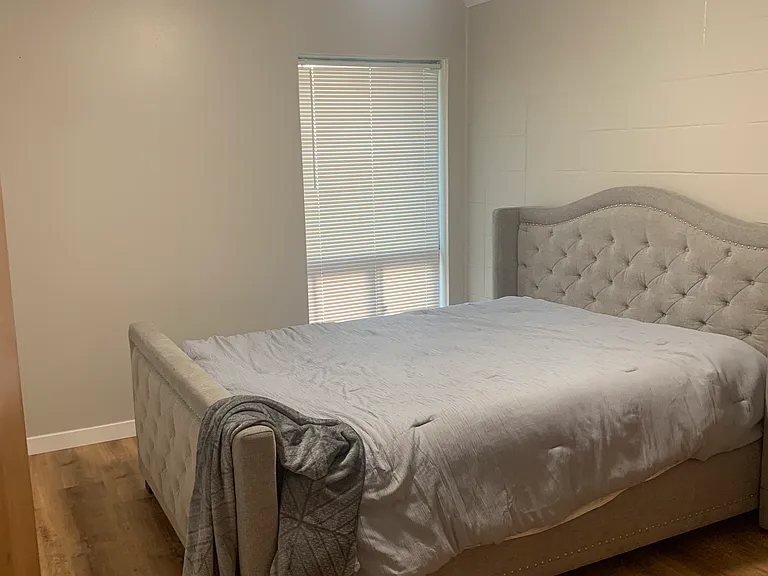 Bedroom with queen bed and headboard and dresser
