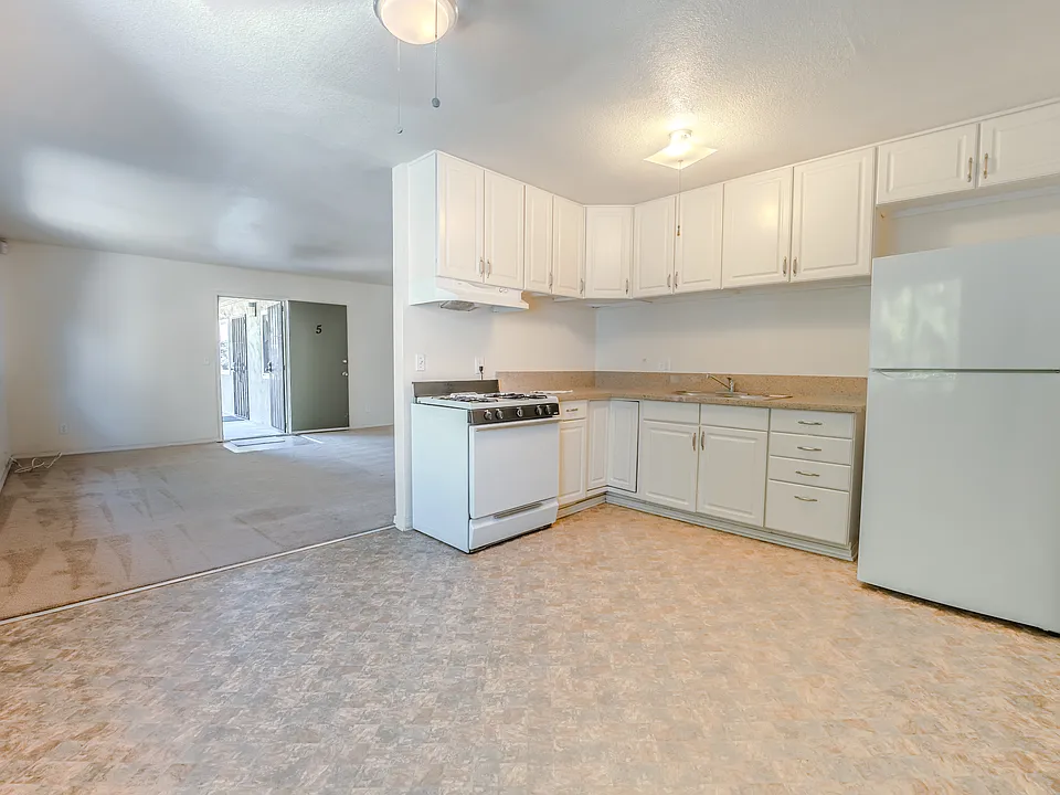 Entry door to large living room with nice updated large kitchen and dining area space with new counter (frig and gas oven)