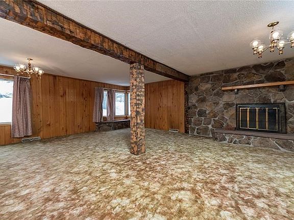 GREAT ROOM [26X23] WITH CUSTOM STONE FIREPLACE AND HAND HEWN WORMY CHESTNUT BEAMS AND POSTS.