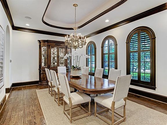 Formal Dining has hardwood floors, raised tray ceiling with cove lighting and triple arched windows with plantation shutters. Chandelier is reserved. Note speakers with volume control in most rooms.