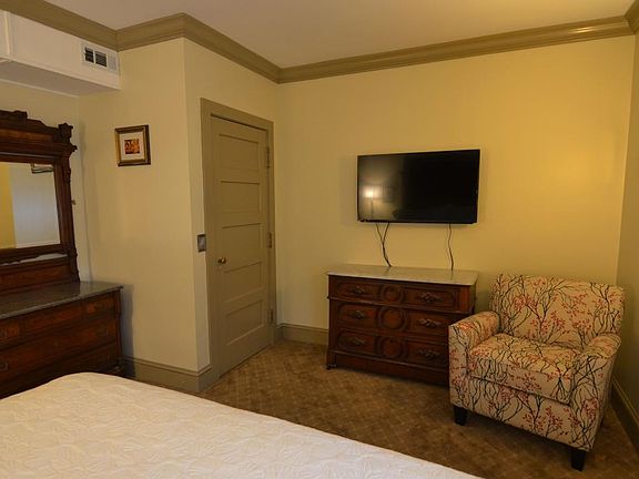 Bedroom with king bed, luxurious carpeting, large flat scree