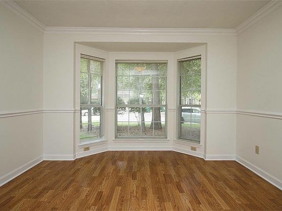 Formal dining room with bay window views into the front yard