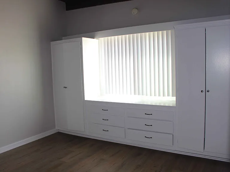 Bedroom, showing a built-in chest of drawers under an ocean-view window and flanked by extra storage areas.