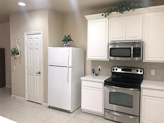 The kitchen located immediately off the open living area is light and bright with upgraded 42" cabinetry, corian countertops and built-in stainless steel appliances. The refrigerator will stay.