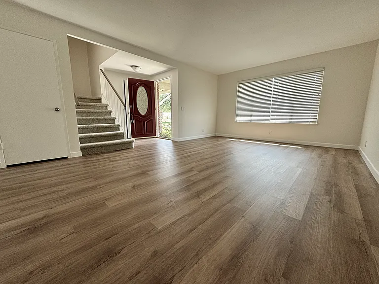 Spacious living room with an abundance of lights boast new vinyl plank flooring and new paint!