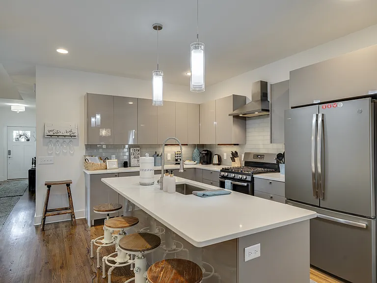 The spacious kitchen offers abundant lighting, a generous prep area, and a large center island with handcrafted custom bench seating, creating the perfect space for cooking, dining, and gathering with family and friends.