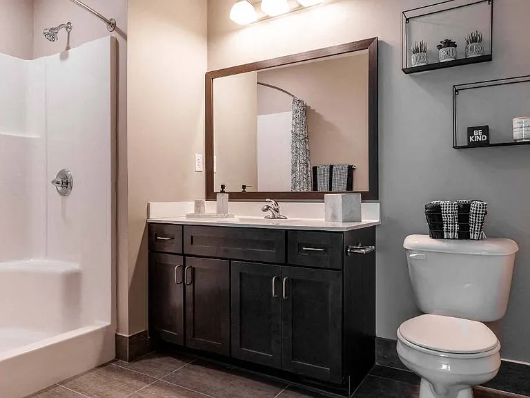 Primry bedroom's bathroom with large step-in shower, vanity, and tile flooring.