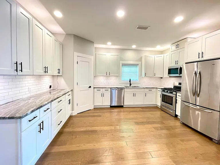 Modern kitchen - white shaker cabinets, granite countertops, over/under cabinet lighting, gas range/oven, stainless appliances (refrigerator is negotiable).