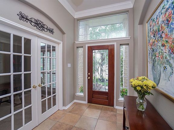 Entry hall features tile floors, art niche, and French doors lead to the study.