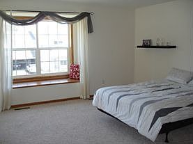 Big master with two sets of windows, two closets, and dressing area with sink.