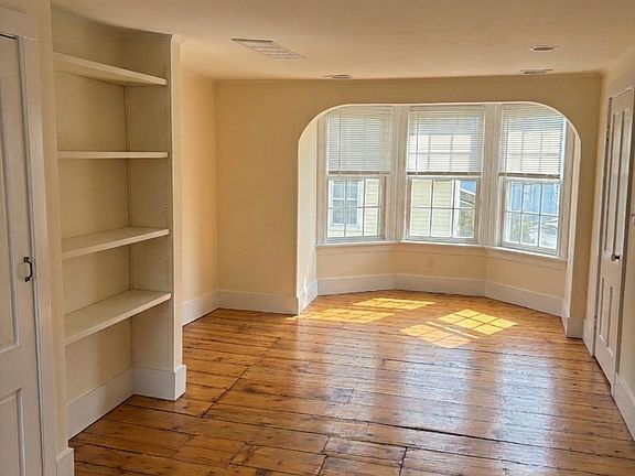 Large living room with built in shelving and lots of light