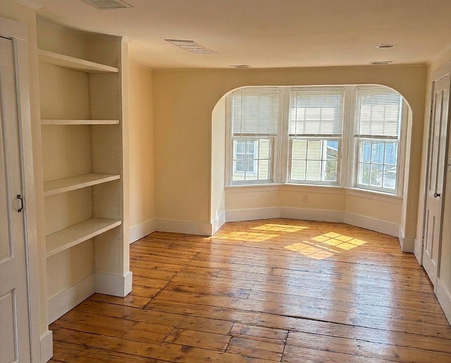 Large living room with built in shelving and lots of light