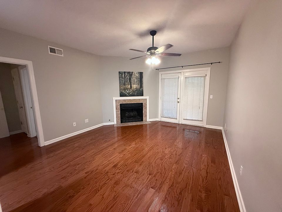 Open living room with vaulted ceilings and door to covered patio