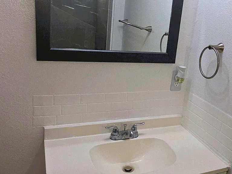 Modern vanity with a mirror, sink, and towel rack for everyday convenience.