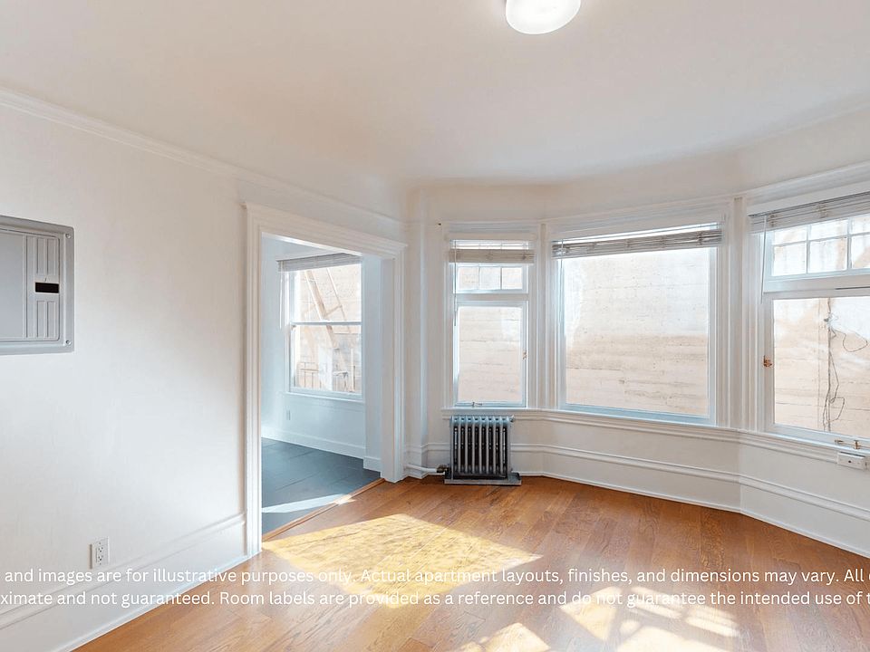 Bright room with wooden floors, bay windows. A small radiator is under the windows. Daylight casts soft shadows, creating an airy feel.