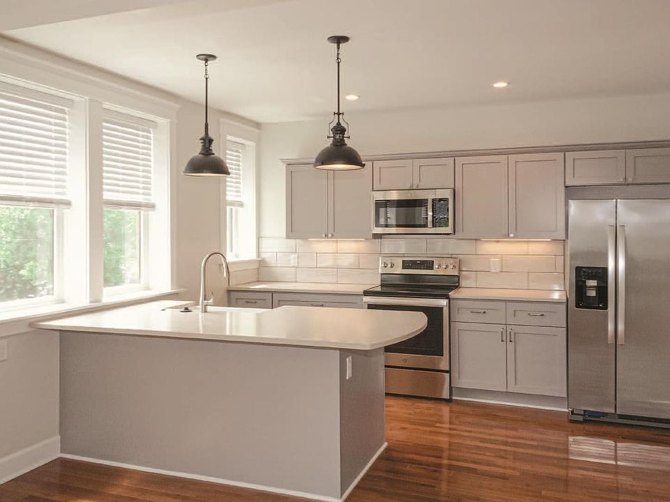 Kitchen with farms sink, bar seating, and new stainless steel appliances.