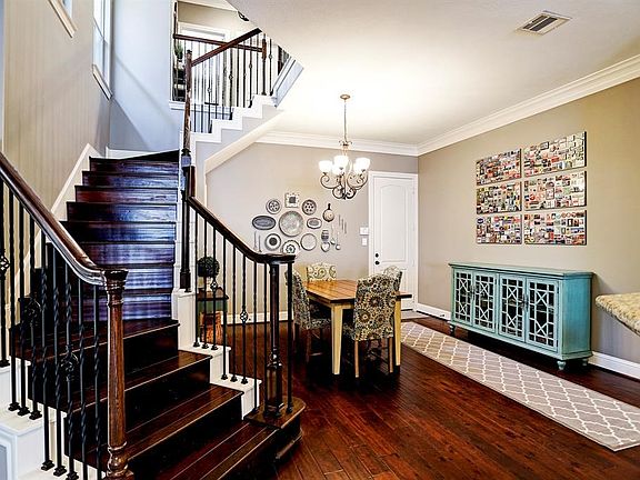 Gorgeous hardwood and wrought iron stairway leading up to the second story bedrooms and flex space.  This space is of the dining area off the kitchen with access to the garage.  The dining area has hand grooved flooring, crown molding and open access to k