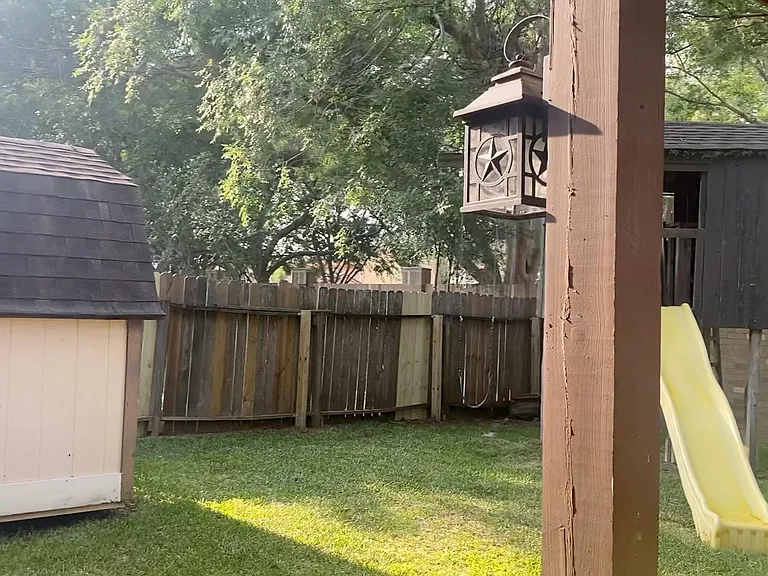 Backyard with large patio, clubhouse, and large storage unit.