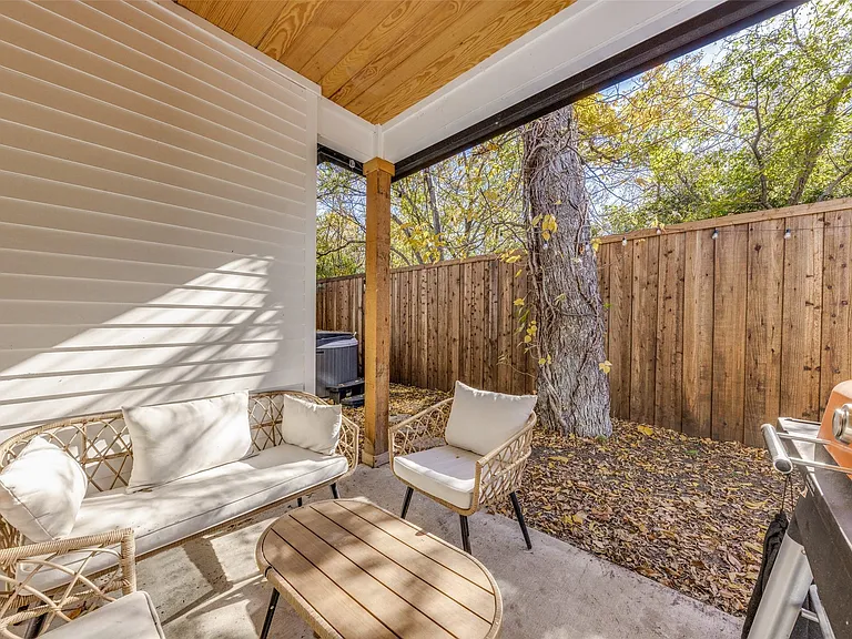 Private outdoor patio featuring a concrete slab and wood fence