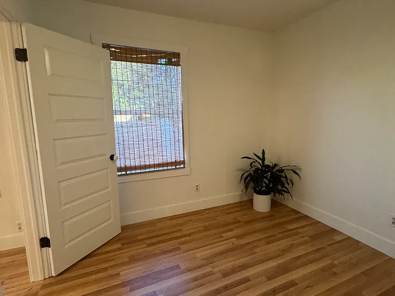 View of the bedroom from the closet side. The window looks out over the front yard