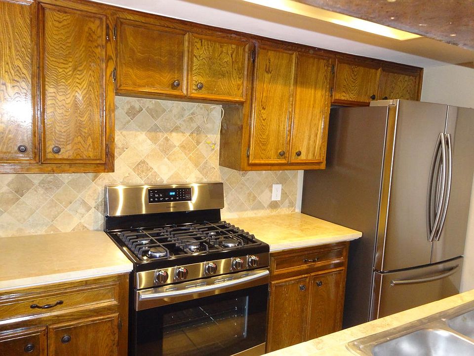Travertine Tile counters. 5 burner gas stove, Double Door stainless refrigerator with bottom freezer.