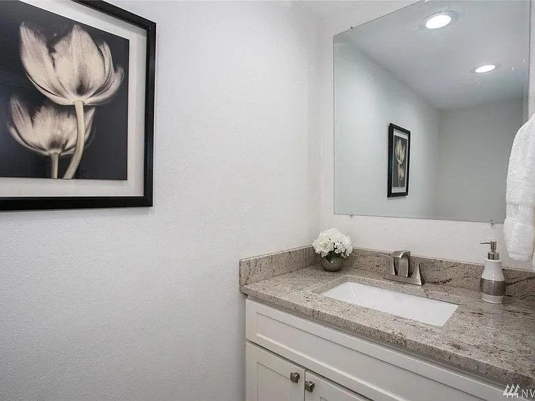 Bathroom updated with vanities, custom tiling, and modern finishes