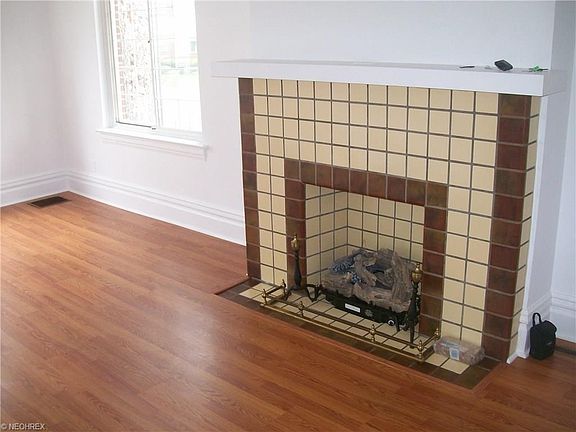 Gas log fire place in living room enhanced by new laminate floor.