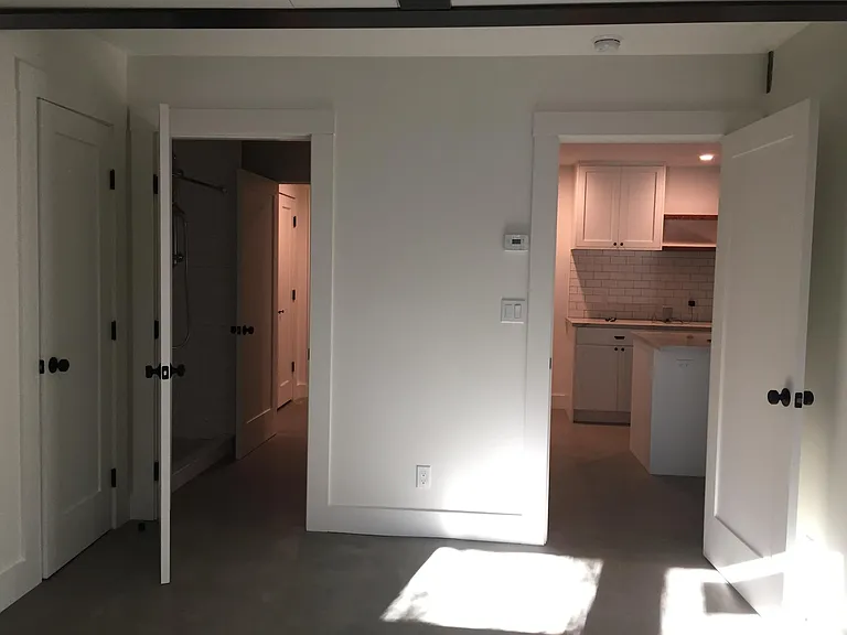 View from bedroom into bathroom (and hallway beyond) and into kitchen.