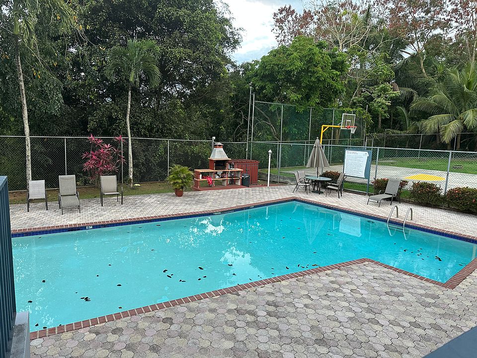 Piscina, cuenta con sus sillas y mesas, tiene un gazebo pequeno y area de barbacoa; cancha de baloncesto se observa de fondo