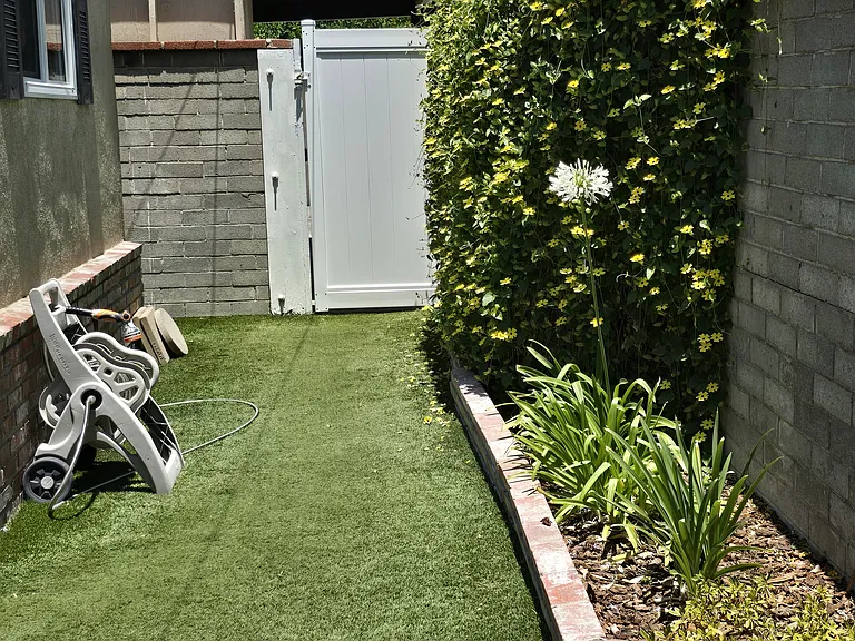 This view is from the private yard. This flower bed is the flower bed looking outside the kitchen window. This gate and walkway leads to the carport parking area This gate is also lockable.