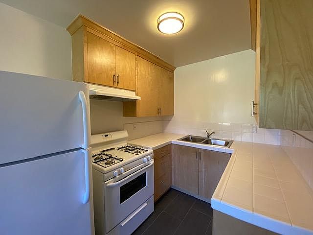 Kitchen view with stove and fridge included and custom wood cabinets