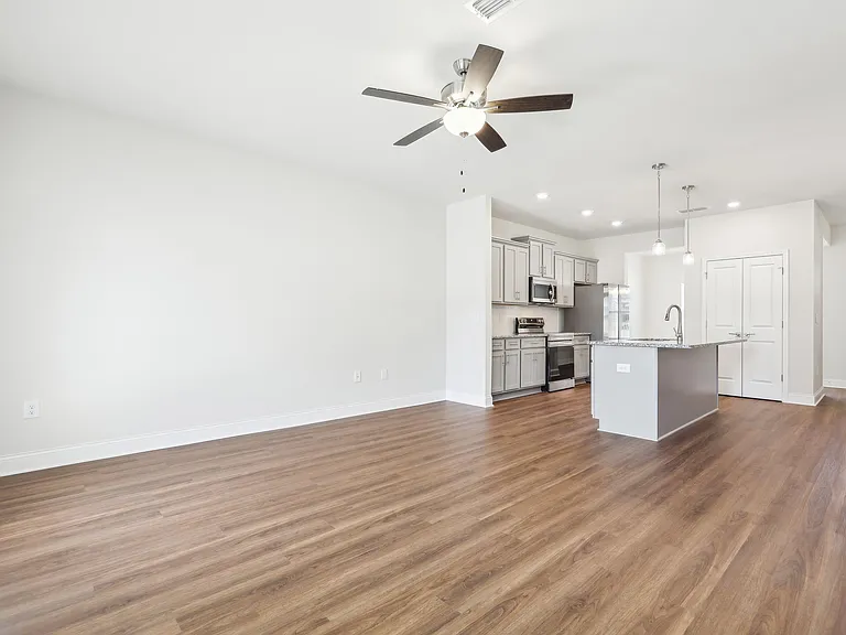 Spacious kitchen equipped with a refrigerator, sink, and ceiling fan.