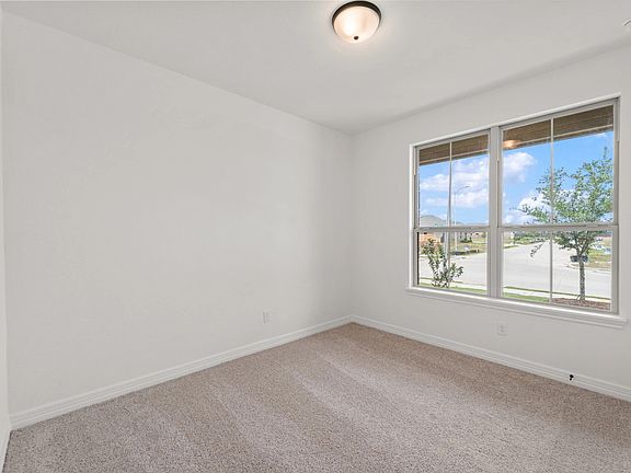 The fifth bedroom features plush carpet, fresh paint, closet, and a large window that lets in plenty