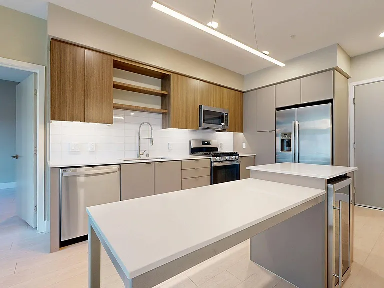 Apartment Kitchen with Quartz counter tops and Wood-Style Flooring.