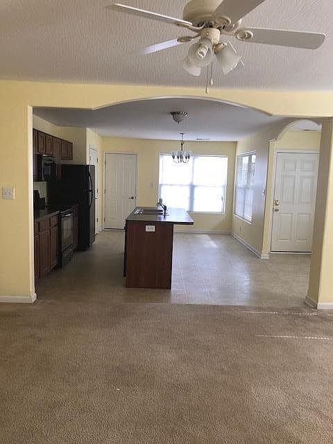 Living room looking into kitchen with arch entry way.