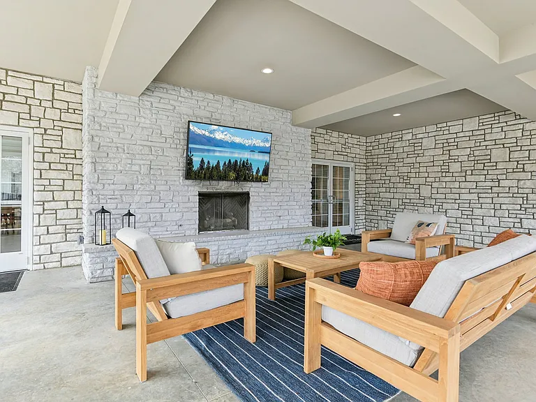 Unwind and reconnect in this inviting outdoor haven, centered around a cozy stone fireplace and plush seating.