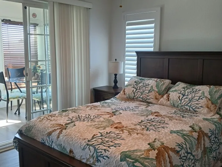 Bedroom 2 with access to a beautiful enclosed front porch with table and chairs plus a huge electronic couch