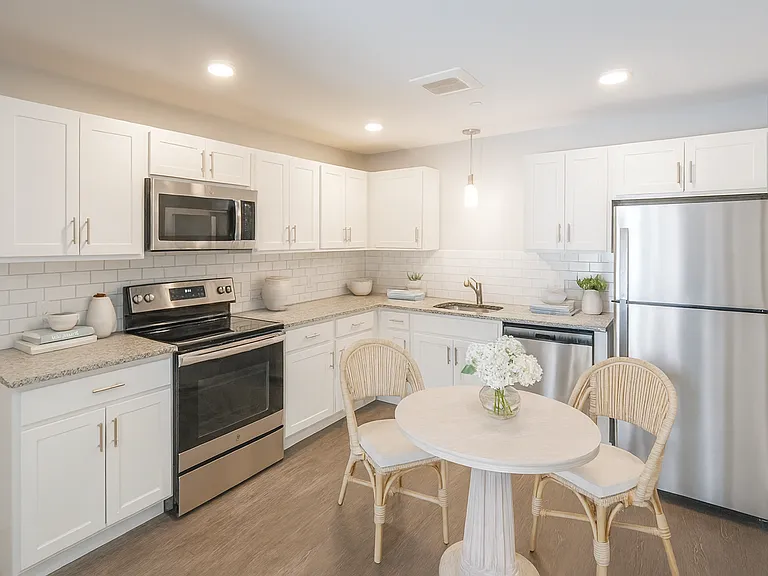 White kitchen cabinets, granite countertops and stainless steel appliances.