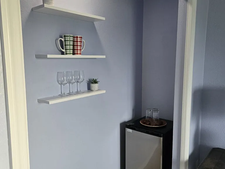Private beverage station featuring a mini fridge and hanging shelves, perfect for storing drinks, coffee supplies, cups, or adding your own decorative touches.