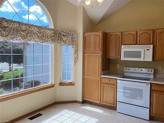 Enter the bright eat in kitchen off of the foyer.  Cathedral ceilings, ceiling fan, ample cabinetry.  Electric range and new dishwaher.  There is not a refrigerator.